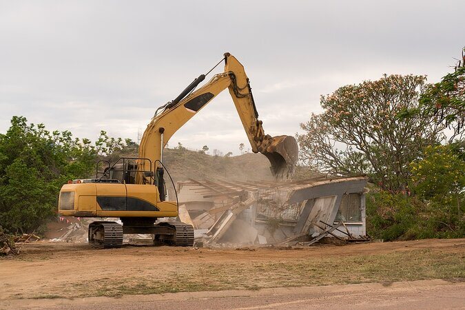 excavator knocking down house